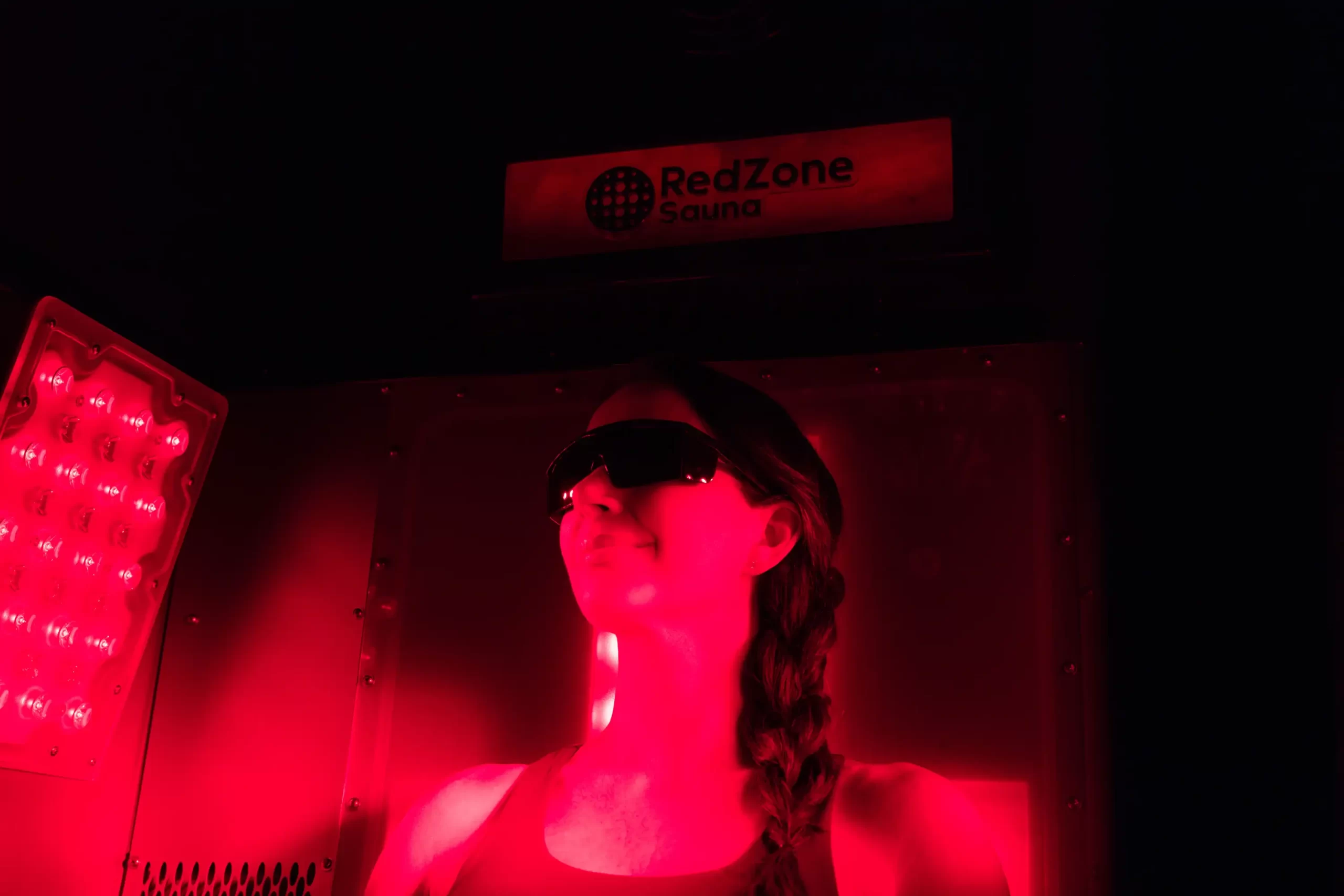 Mujer relajándose dentro de RedZone Sauna con tecnología dual de infrarrojo y luz roja